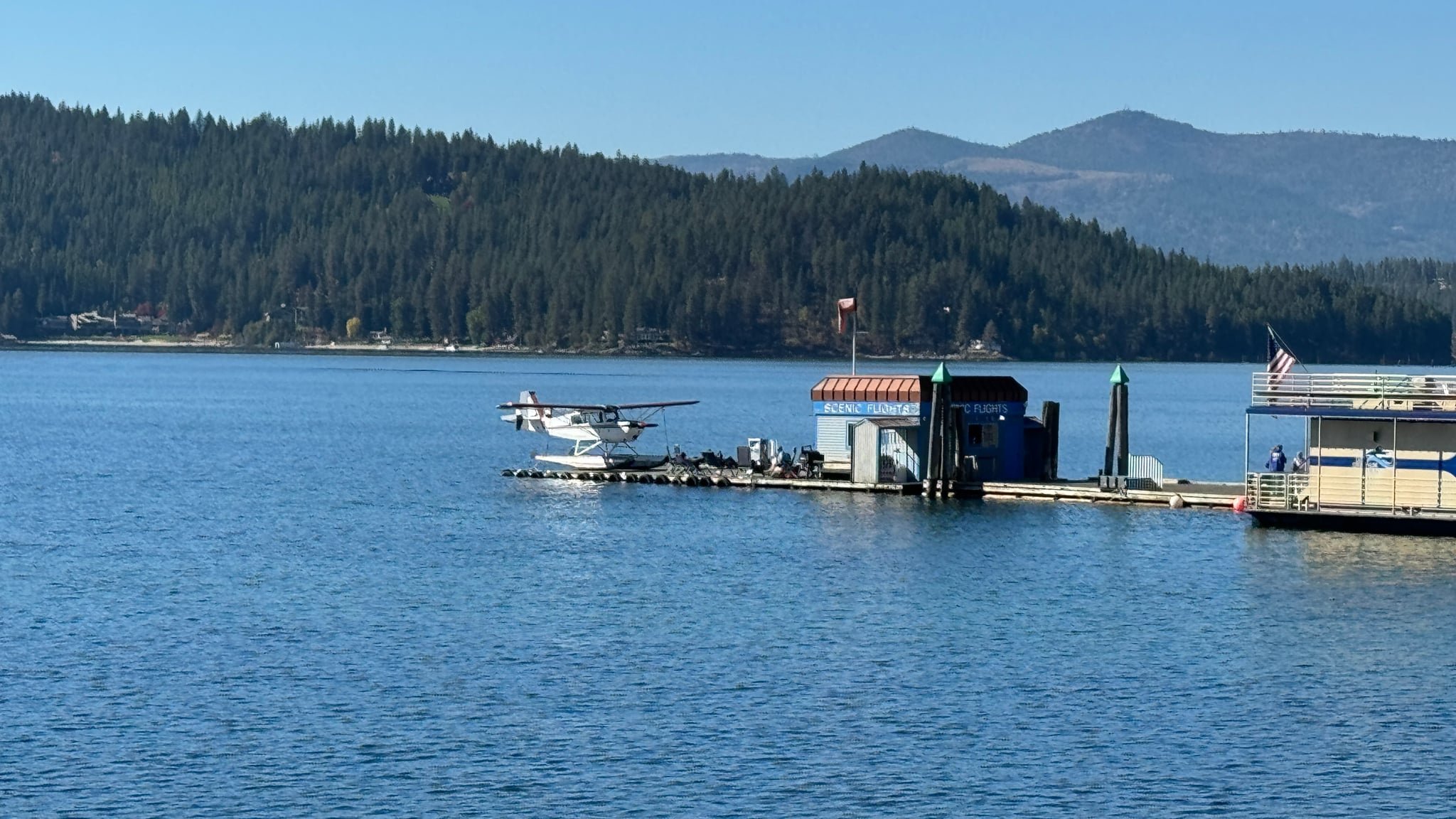 Seaplane and scenic flights dock on a Northern Idaho lake with pine-covered hills